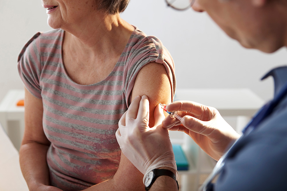 Healthcare provider administering a flu shot to a patient's arm